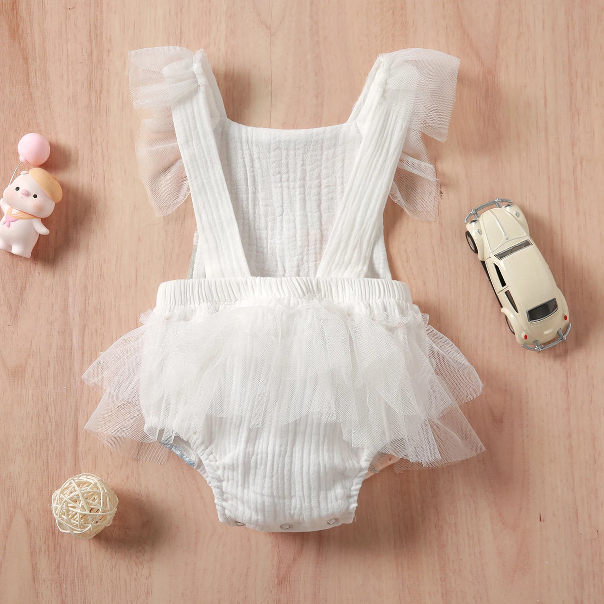 white floral baby romper for infants with sheer ruffle sleeves and tutu skirt detail