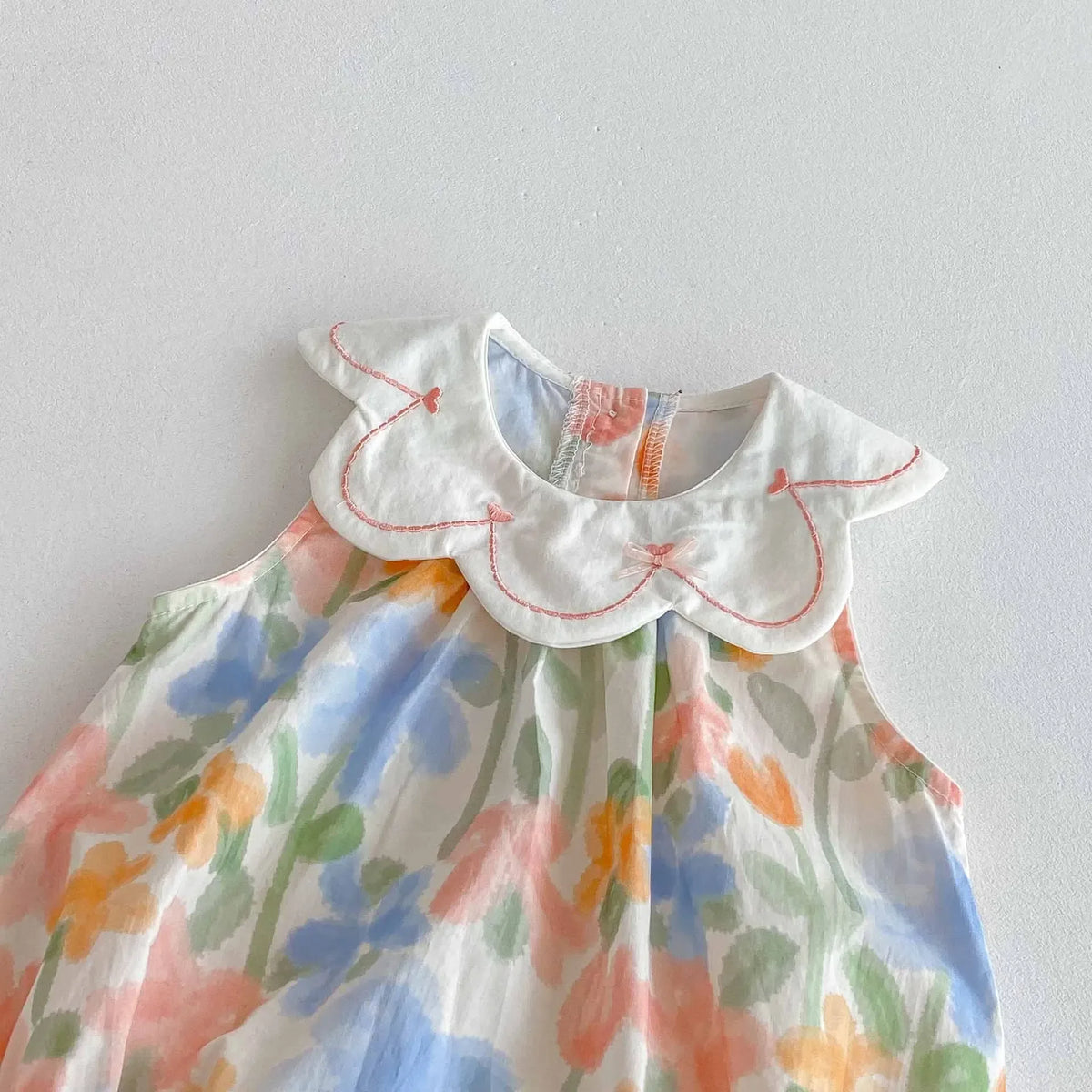 pastel floral baby romper with embroidered collar for infants with scalloped edge detail