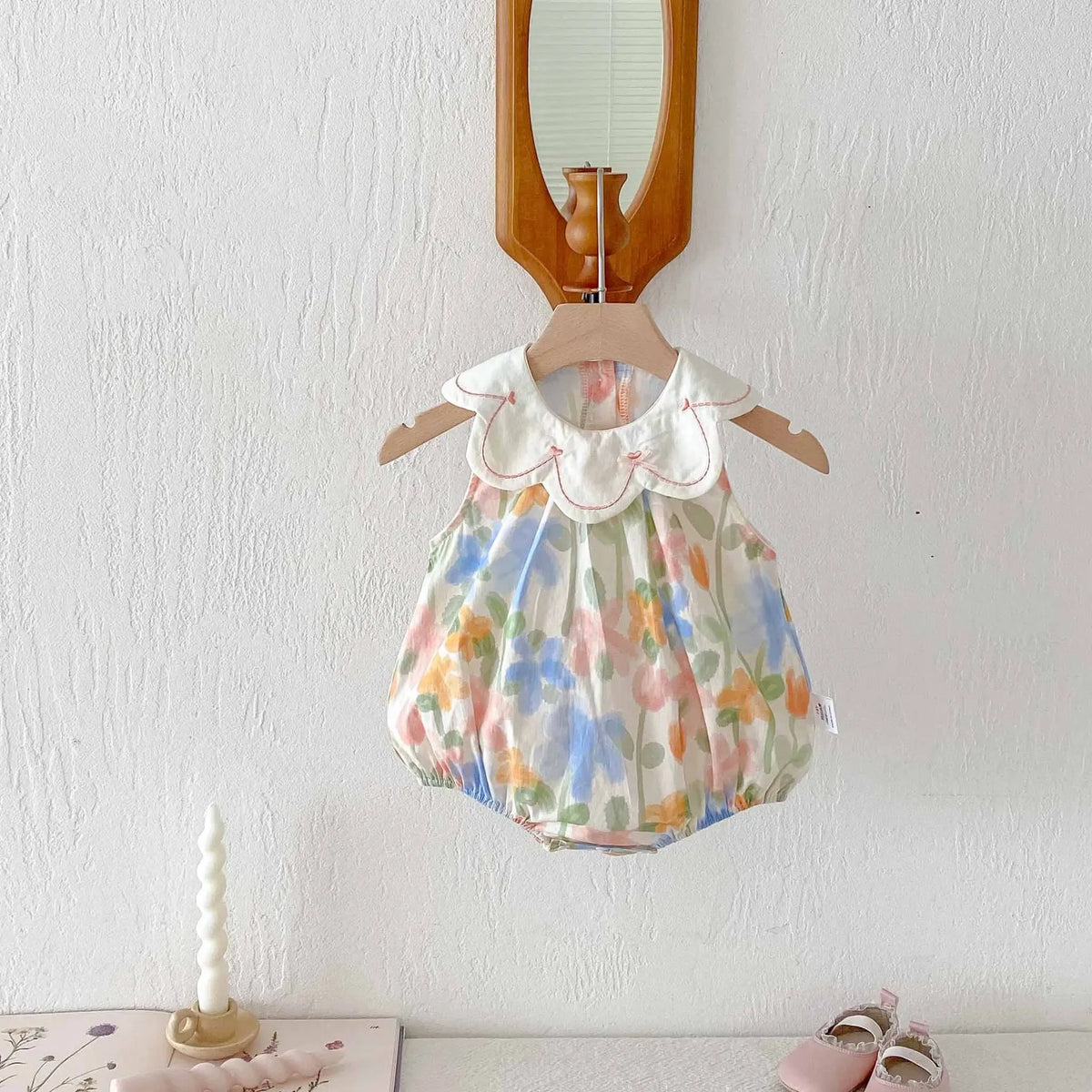 floral baby romper with embroidered collar for infants in pastel colors with scalloped neckline