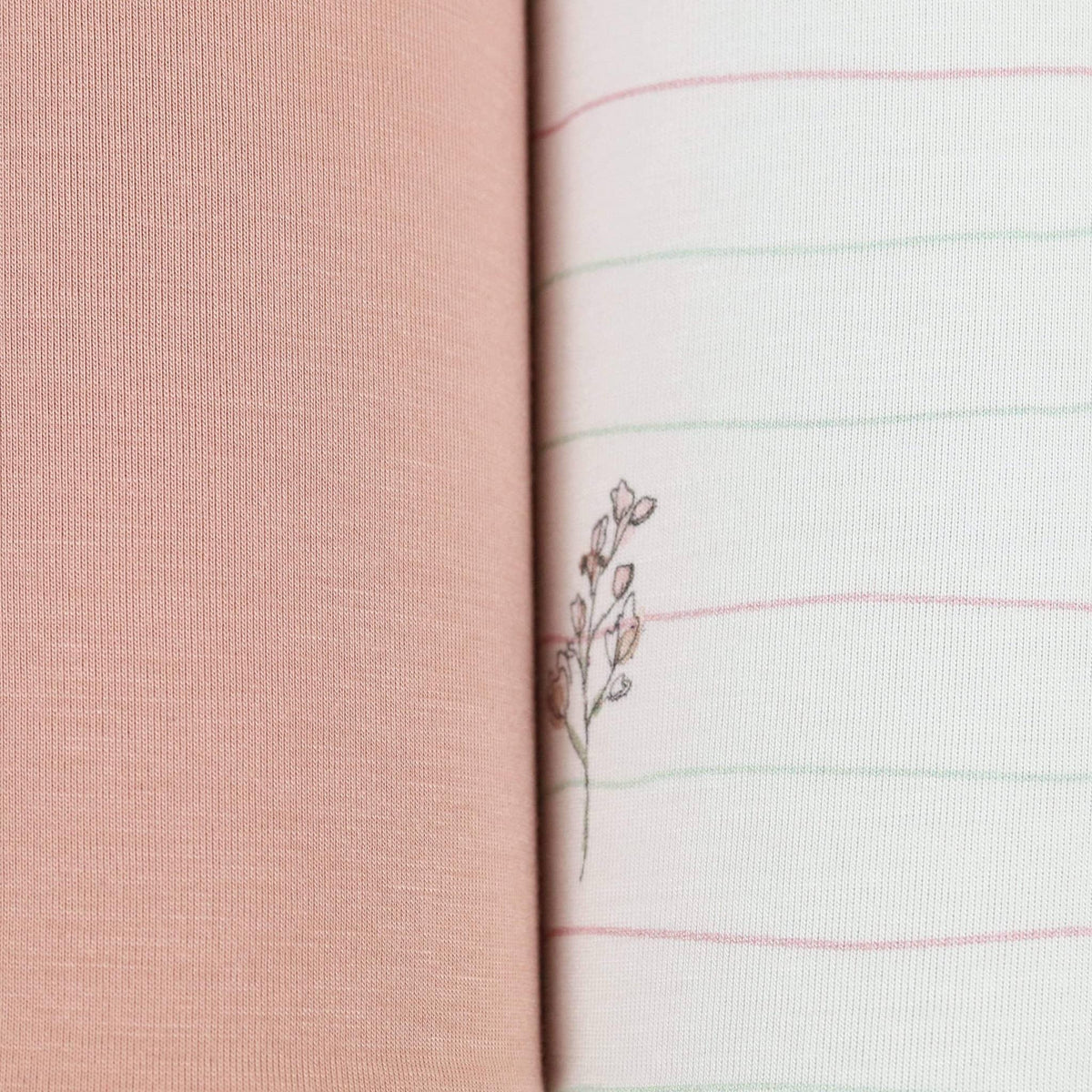 Close-up of flower pink baby swaddle blankets showing soft pink solid and white striped fabric with delicate floral embroidery