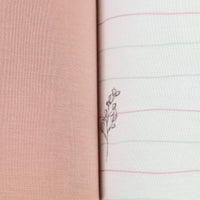 Close-up of flower pink baby swaddle blankets showing soft pink solid and white striped fabric with delicate floral embroidery