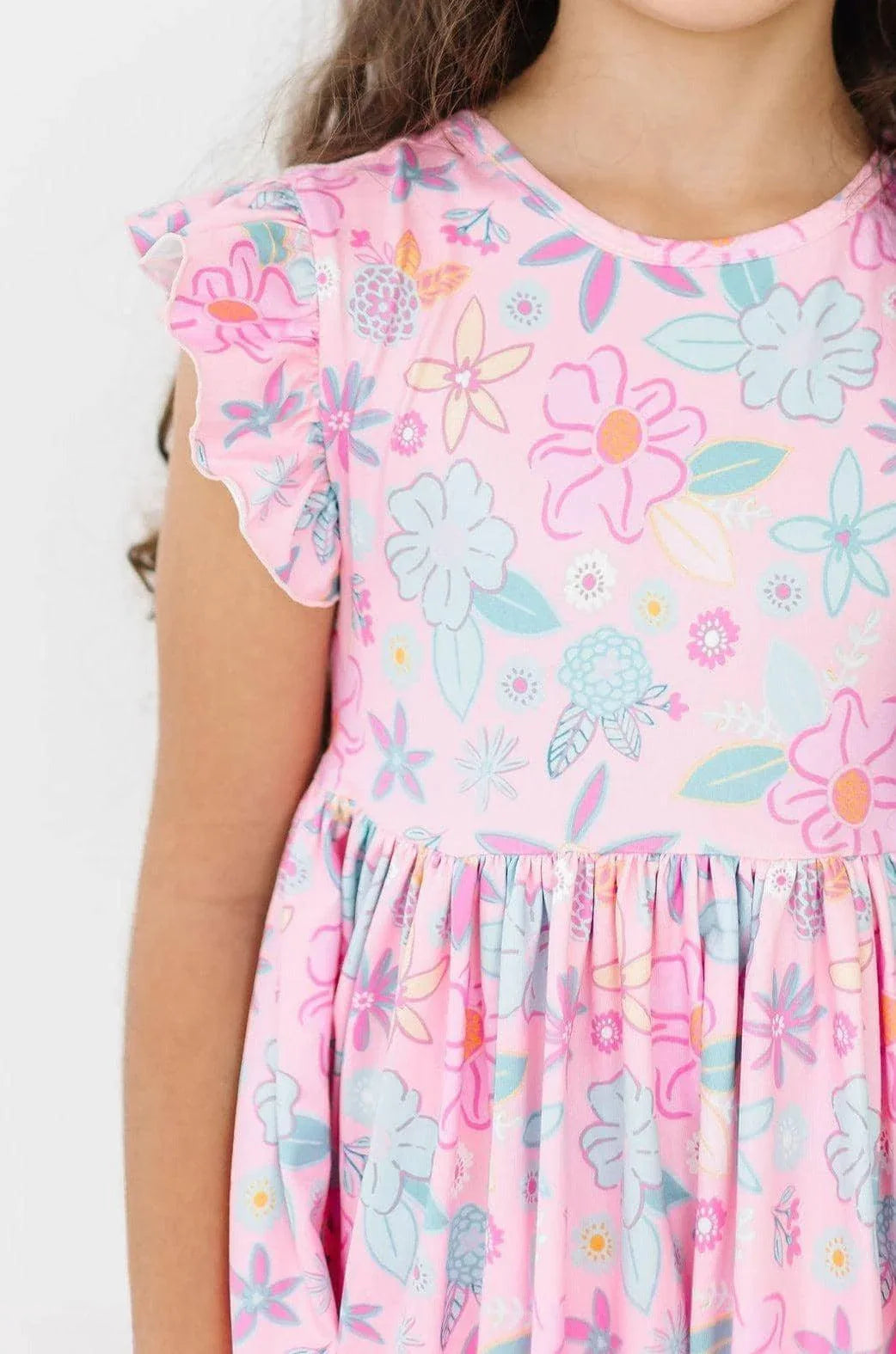 girl wearing pink floral flutter sleeve twirl dress for girls in a standing pose