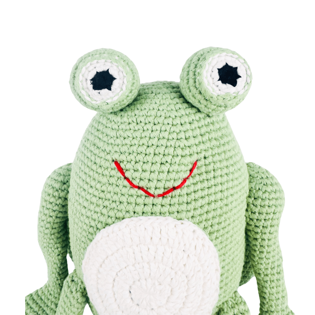 Bright green crochet frog with big eyes, red stitched smile, and white belly. A charming organic cotton stuffed animal for pretend play.