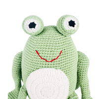 Bright green crochet frog with big eyes, red stitched smile, and white belly. A charming organic cotton stuffed animal for pretend play.