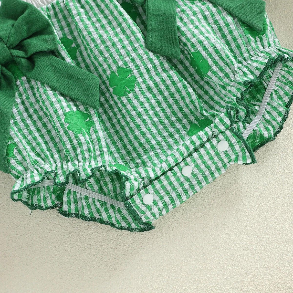 Green and white cotton frilly clover baby bubble romper with button snaps and decorative bows