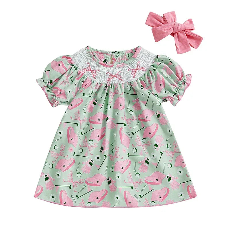 baby girl mint green golf dress with pink golf print and puff sleeves with matching pink hair bow