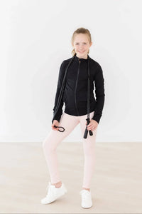 girl wearing light pink girls active leggings standing with jump rope in hand