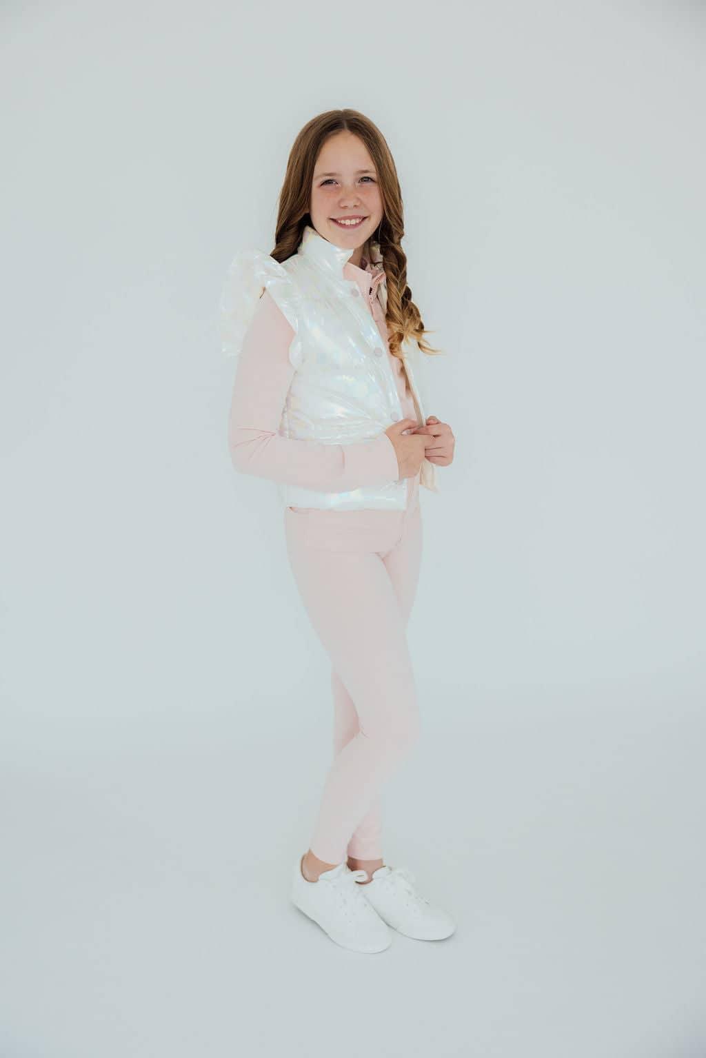 Girl wearing light pink girls active leggings and white vest standing and smiling