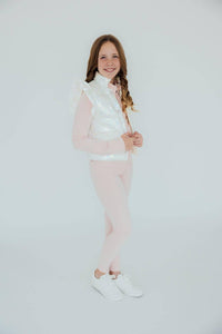 Girl wearing light pink girls active leggings and white vest standing and smiling