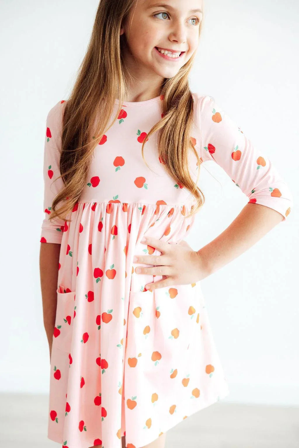 Girls apple print twirl dress by Mila Rose in pink with 3/4 sleeves and pockets