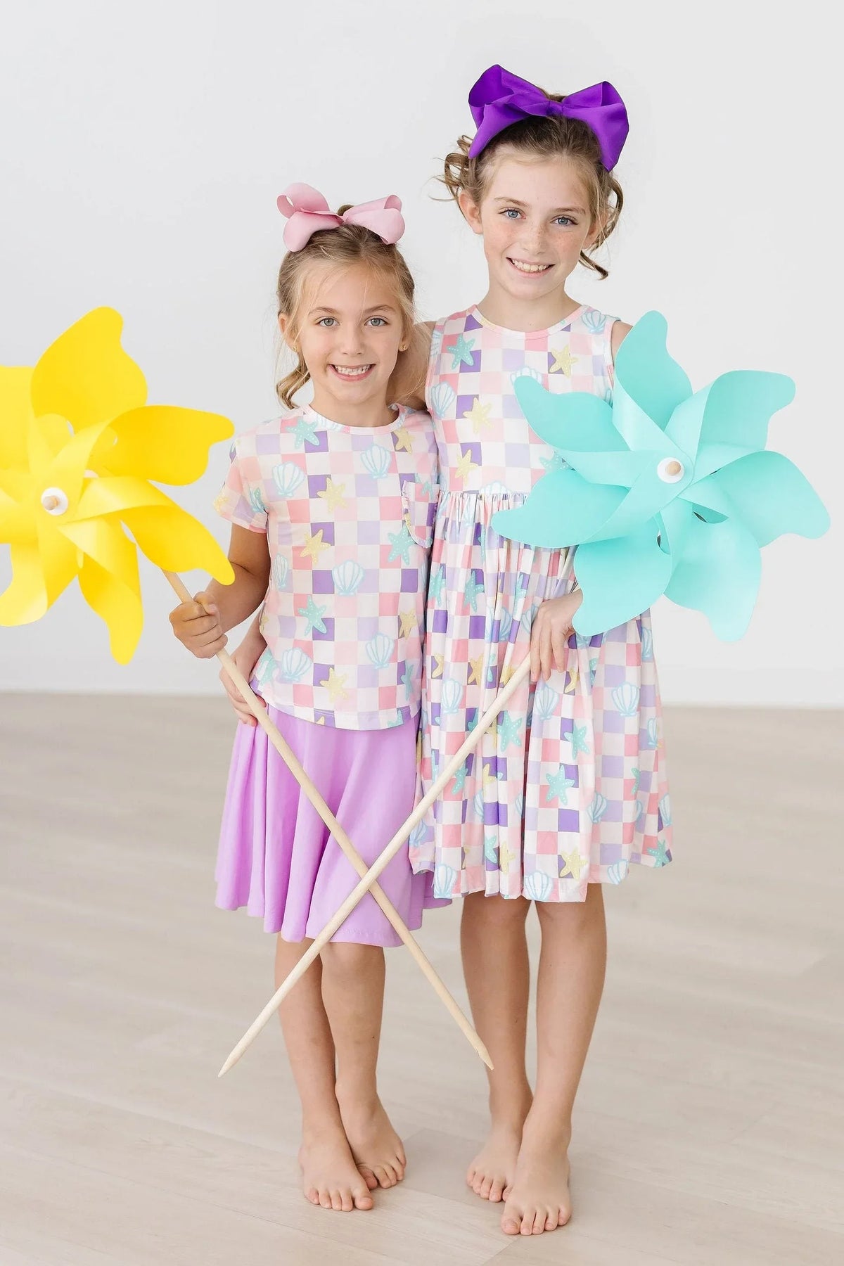 Mila & Rose girls beach dress twirl tank dress in pastel geometric print worn by young girls with colorful bows