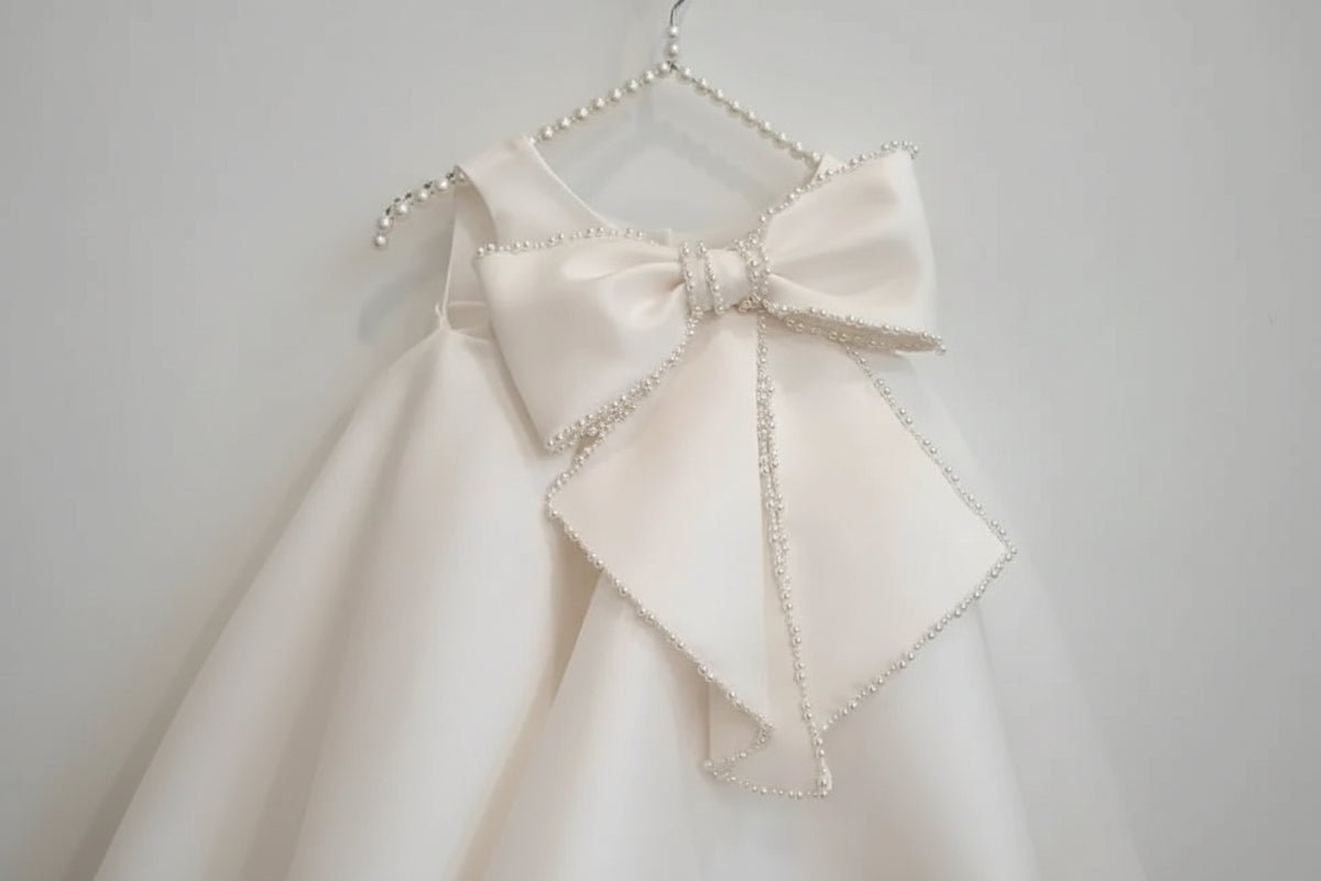 Girls white beaded occasion dress with large pearl-trimmed bow, toddler size