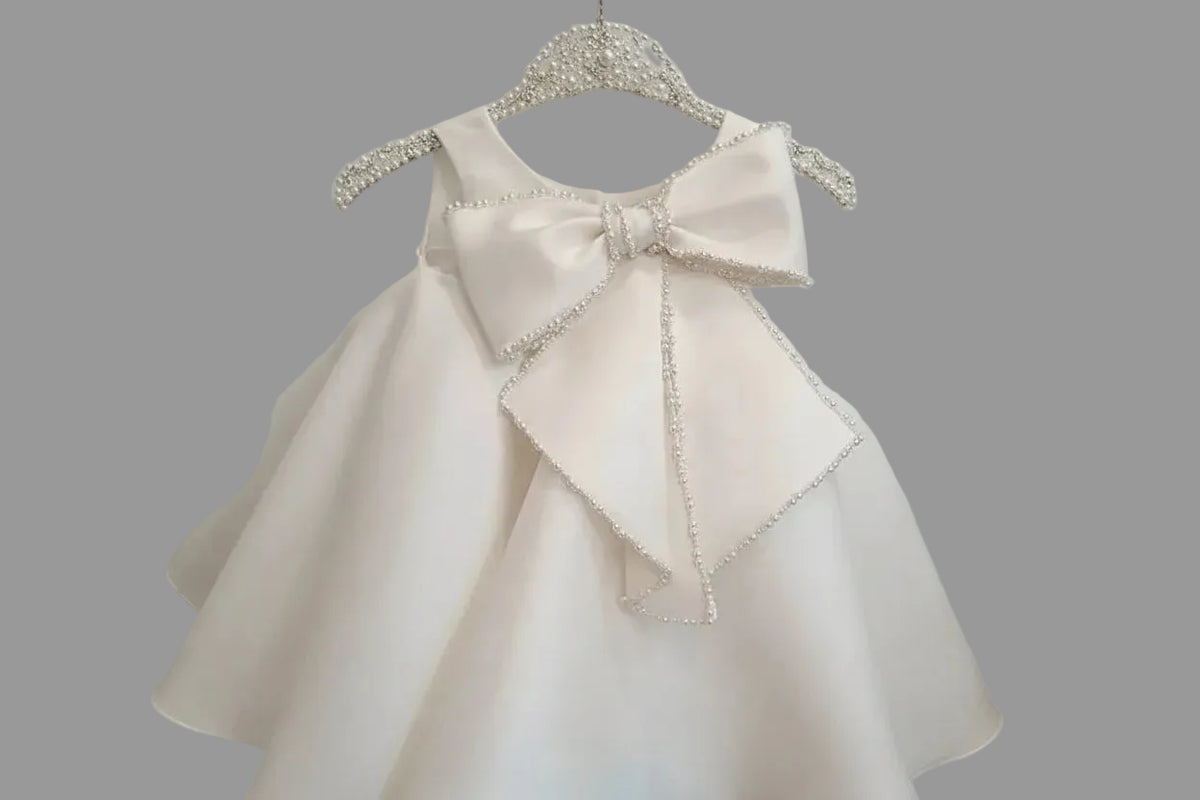 Girls white beaded occasion dress with large pearl-trimmed bow for toddlers