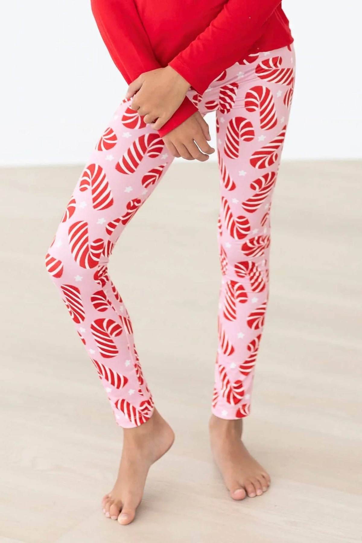 Girls candy cane leggings in white and red festive print, perfect holiday wear for kids