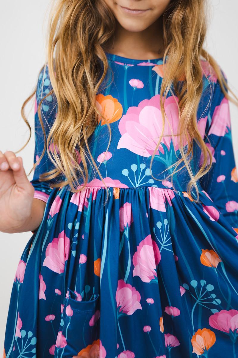 Girls floral twirl dress in blue with pink and orange flowers, sleeves, pocket detail