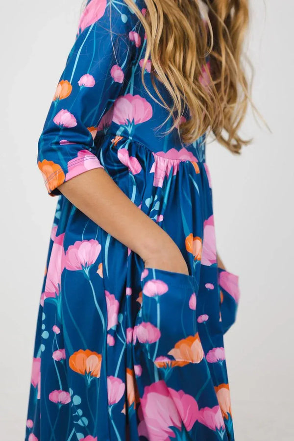 Girls floral twirl dress in blue with pink and orange flowers, sleeves, and pockets