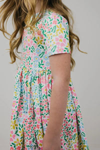 Girl wearing colorful girls floral twirl dress with short sleeves twirling side view