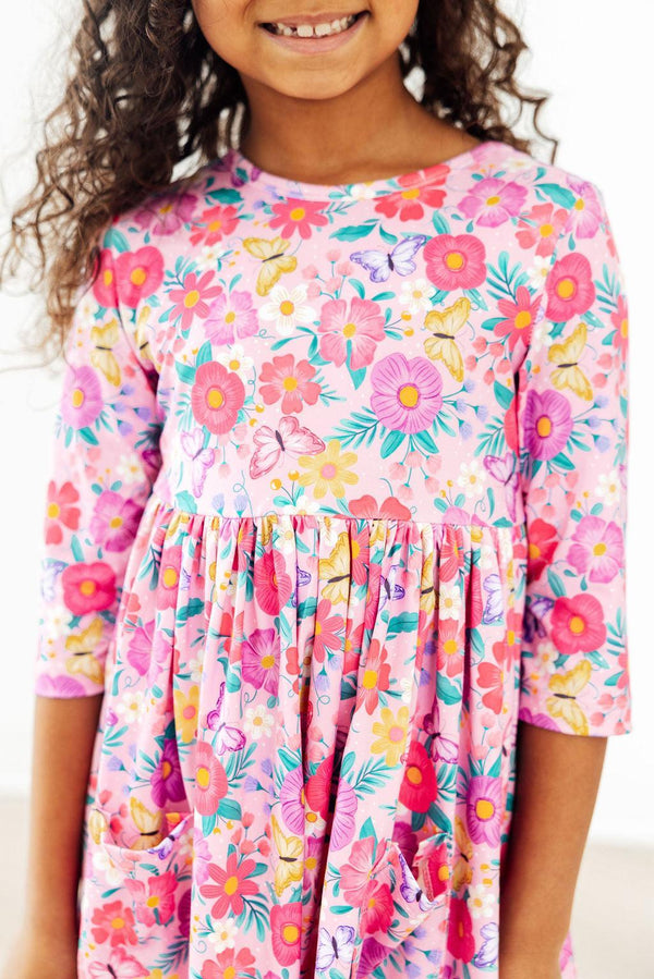 a young girl wearing pink girls floral twirl dress with sleeves smiling