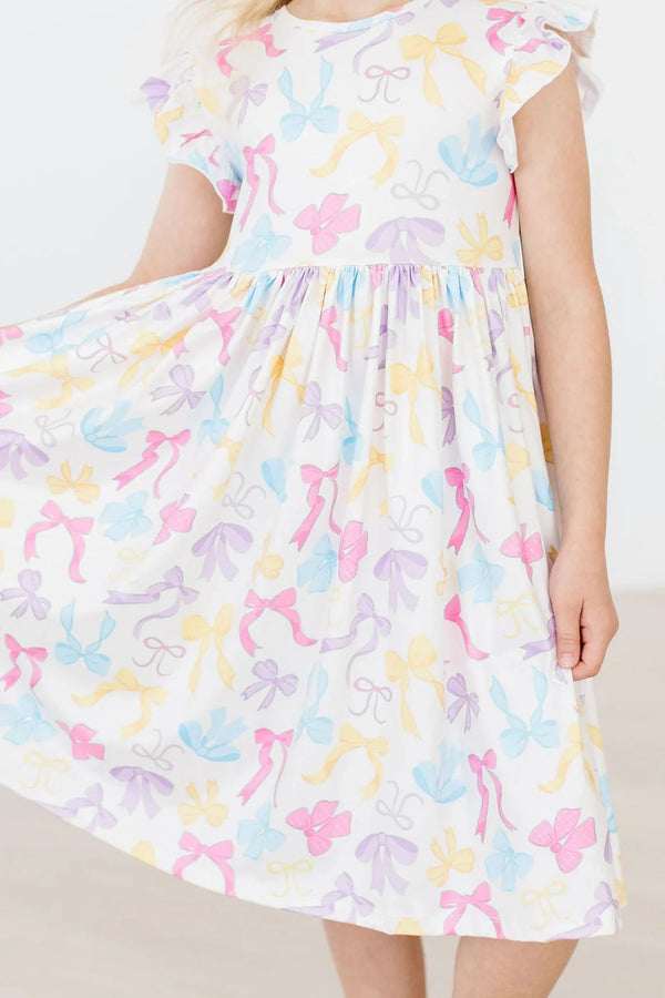Girls flutter sleeve twirl dress in white with pastel bow print for young girls by Mila & Rose