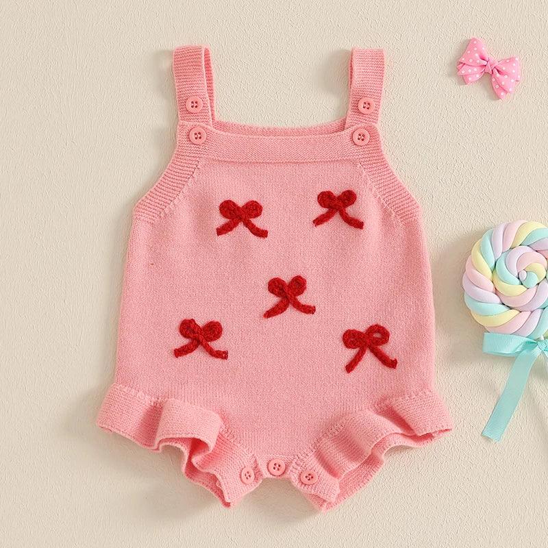 pink girls knitted romper overalls with red bow accents and button straps for infants