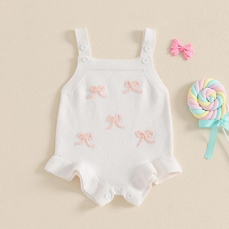 girls knitted romper overalls in white with pink bow details, suitable for babies