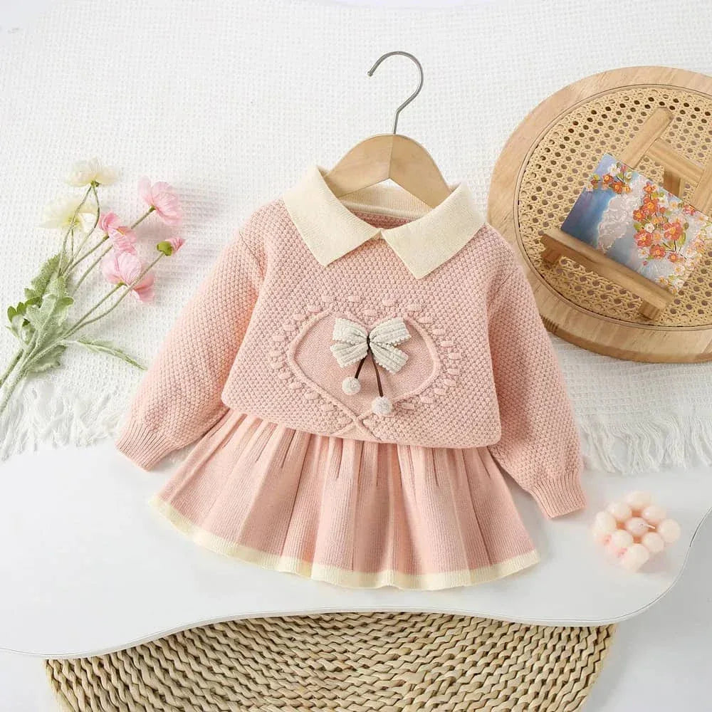 Pink knitted skirt set for girls with heart and bow detail, suitable for toddlers and young children