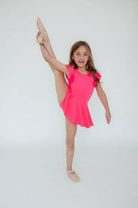 Girl wearing girls neon pink twirl leotard performing high leg stretch pose