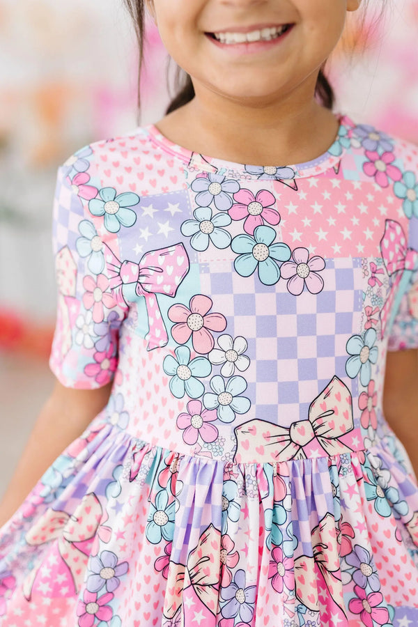 Girls patchwork princess twirl dress in pastel pink and lavender with floral and bow details for young girls