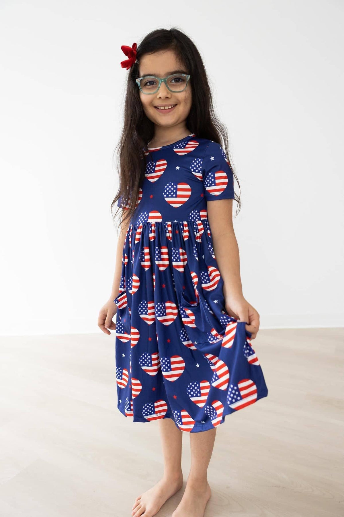 Girls patriotic twirl dress in blue with American flag heart pockets, short sleeve for kids