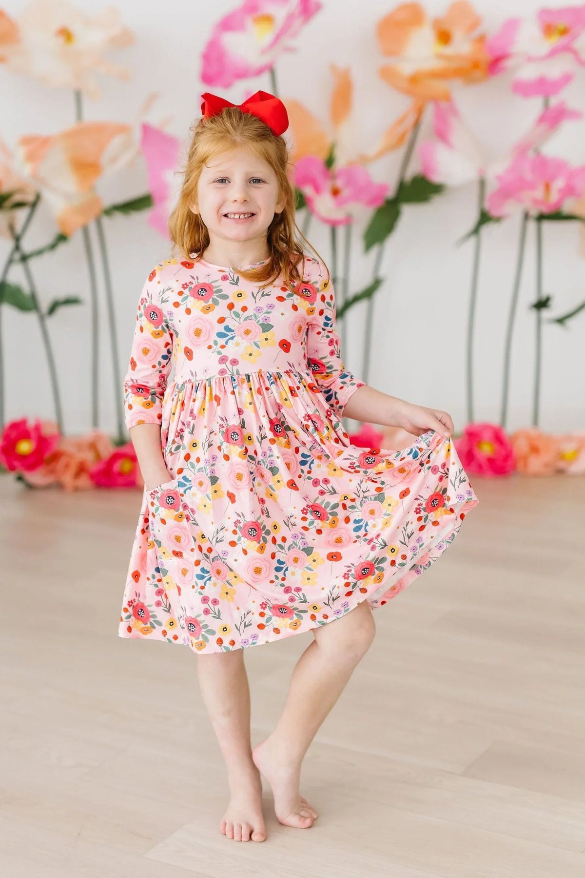 Girls pink floral twirl dress by Mila Rose, 3/4 sleeve, knee-length with colorful flower print