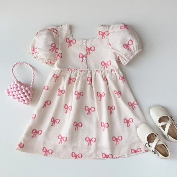 Girls pink party dress with puff sleeves and bow print made of soft fabric for babies and kids