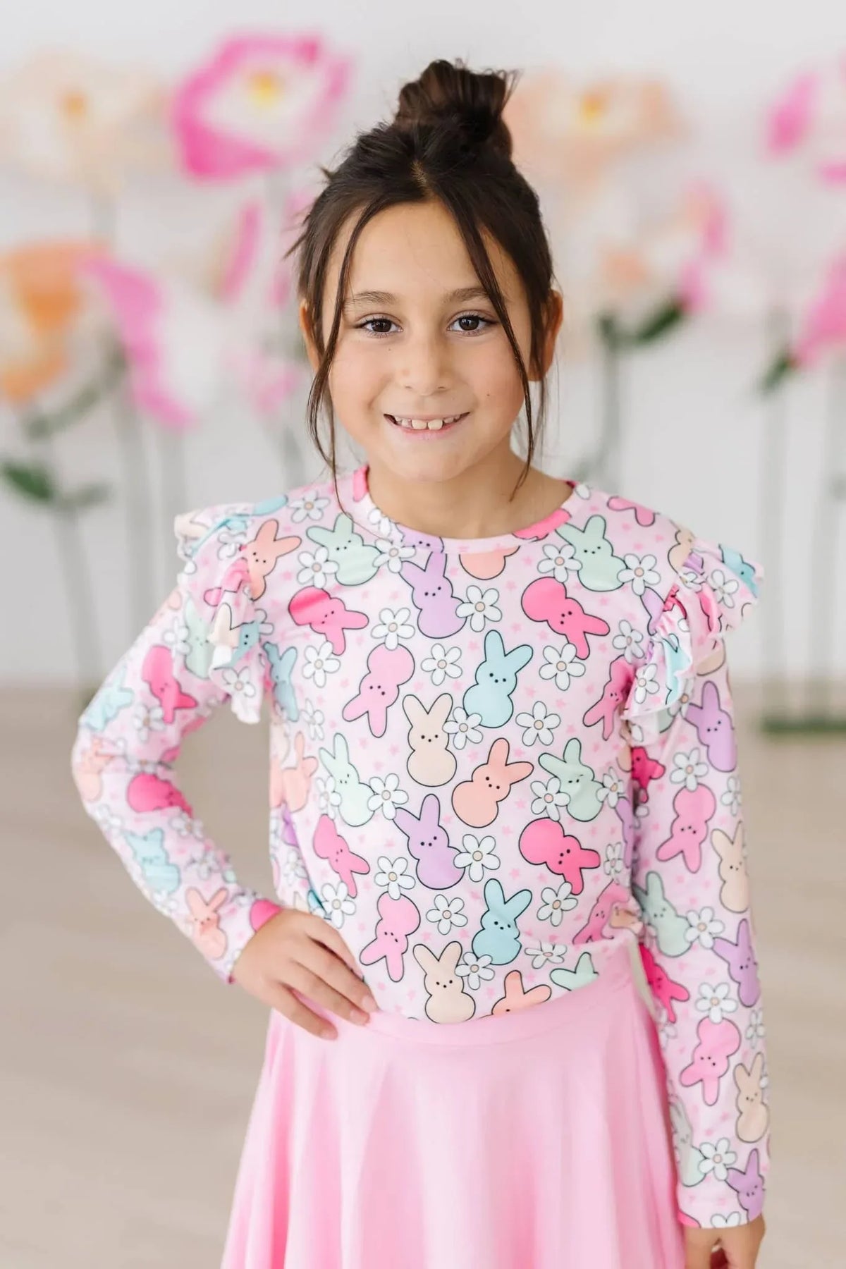 Young girl wearing pastel bunny print girls ruffle long sleeve tee standing and smiling
