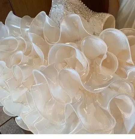 close-up of white girls sequined tiered dress showing layered ruffled skirt details