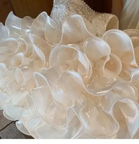 close-up of white girls sequined tiered dress showing layered ruffled skirt details