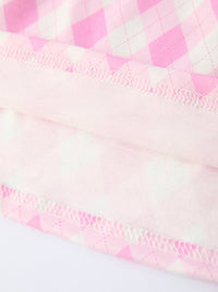 close-up of pink and white girls smocked golf dress fabric showing stitching and quilted pattern