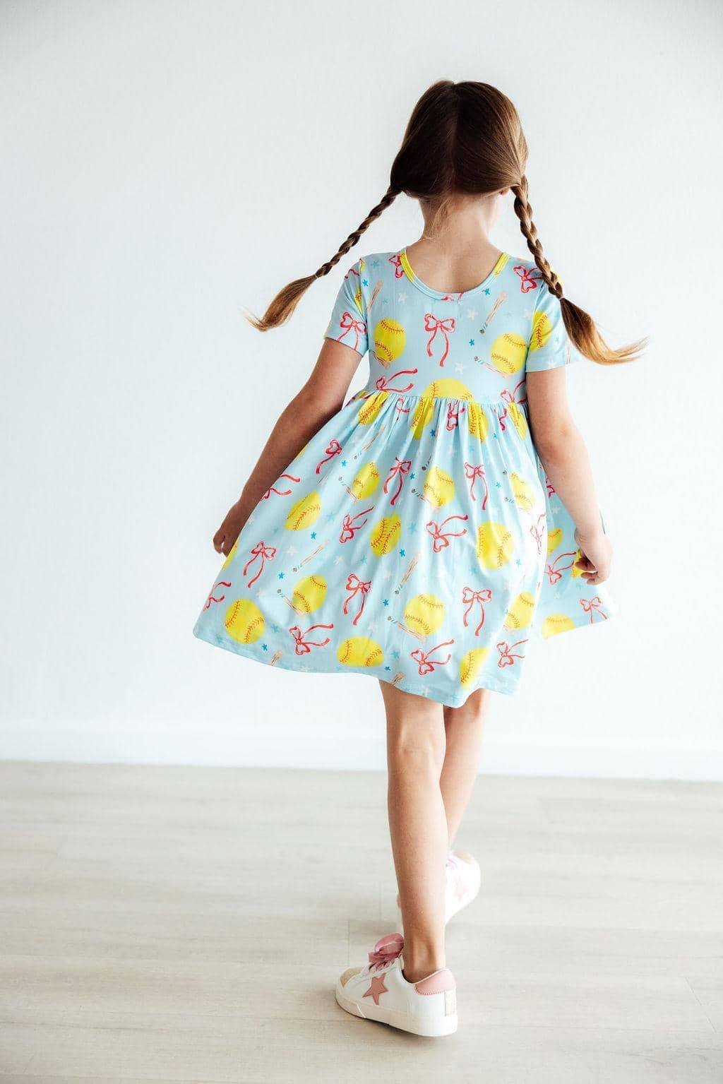 Girls light blue twirl pocket dress with short sleeves and pink bows softball print