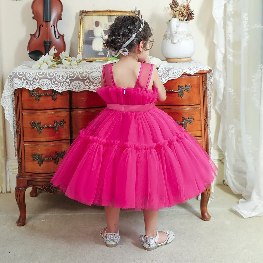 Toddler girl wearing bright pink girls tulle occasion dress with sleeveless straps and full skirt
