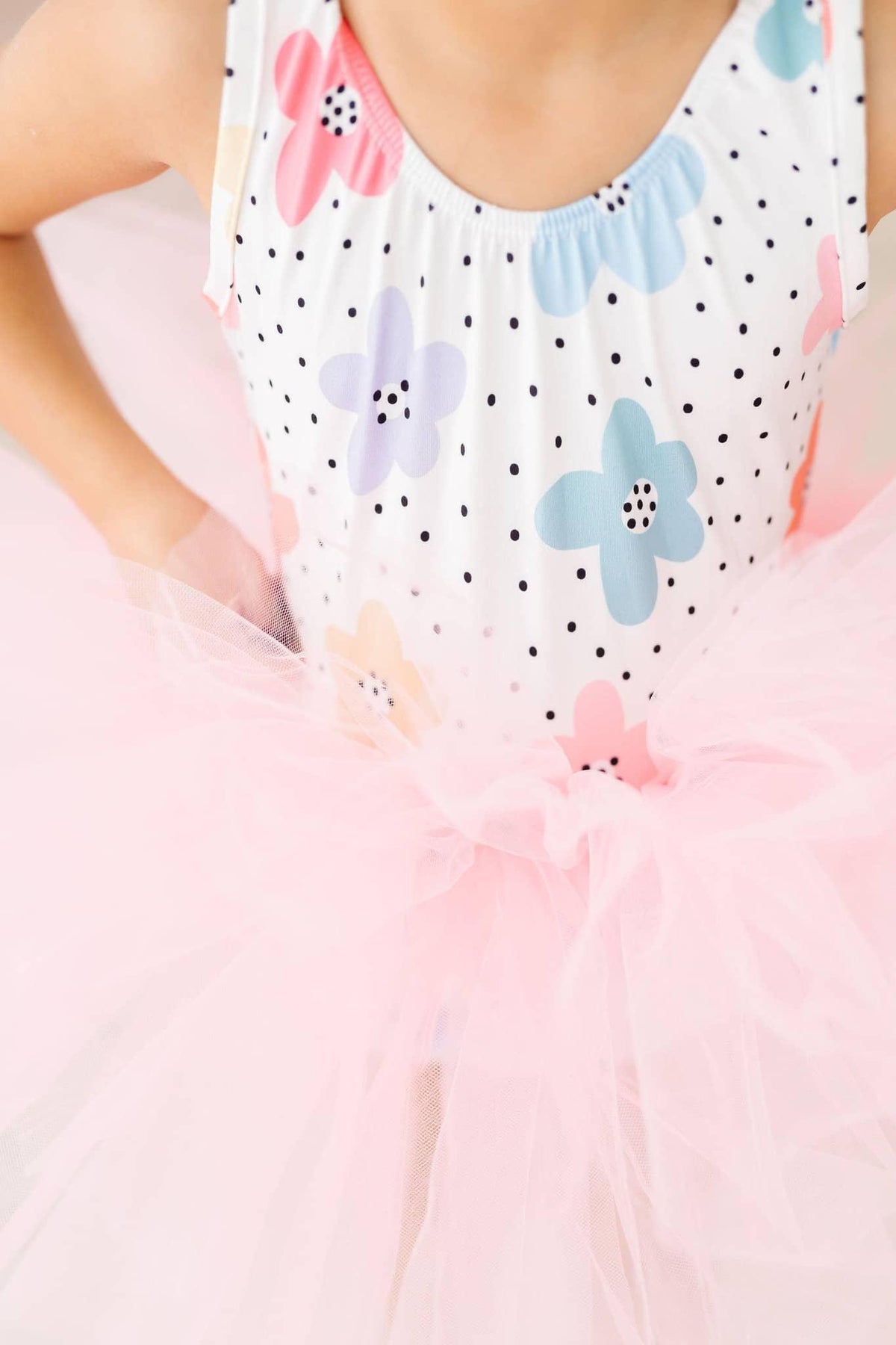 Young girl wearing Mila & Rose girls tutu leotard with colorful polka dot flowers and pink tulle skirt