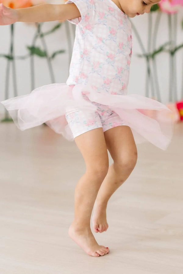 Little girl wearing pink Mila & Rose girls tutu shorts while jumping indoors
