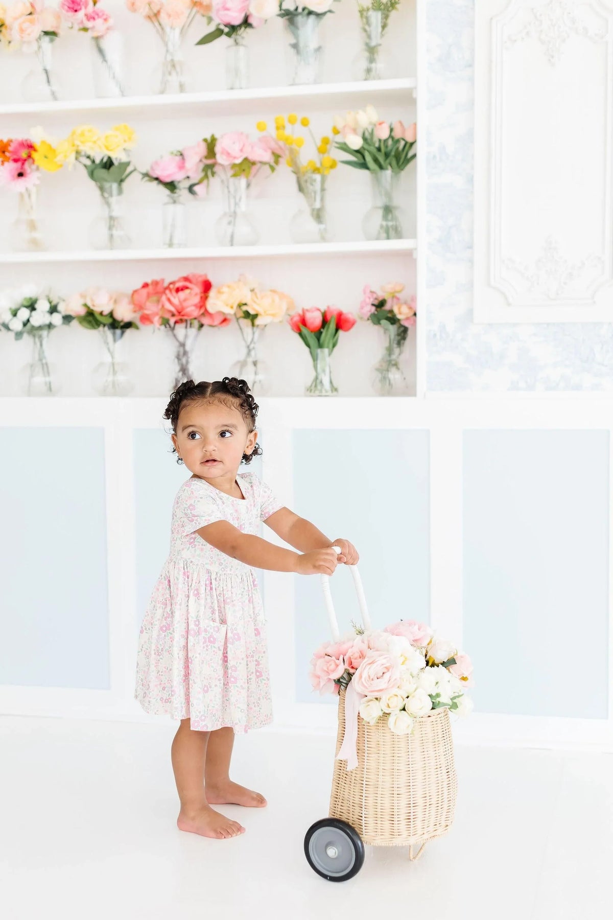 Toddler girl wearing a pink floral girls twirl dress with pockets short sleeve by Mila & Rose