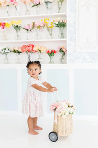 Toddler girl wearing a pink floral girls twirl dress with pockets short sleeve by Mila & Rose