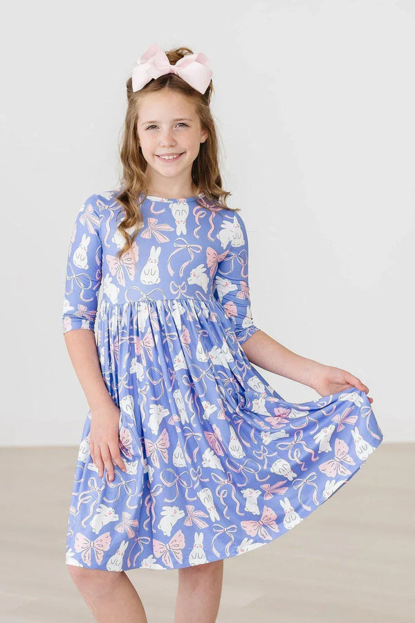 Girl wearing blue girls twirl dress with pockets featuring butterfly print holding skirt