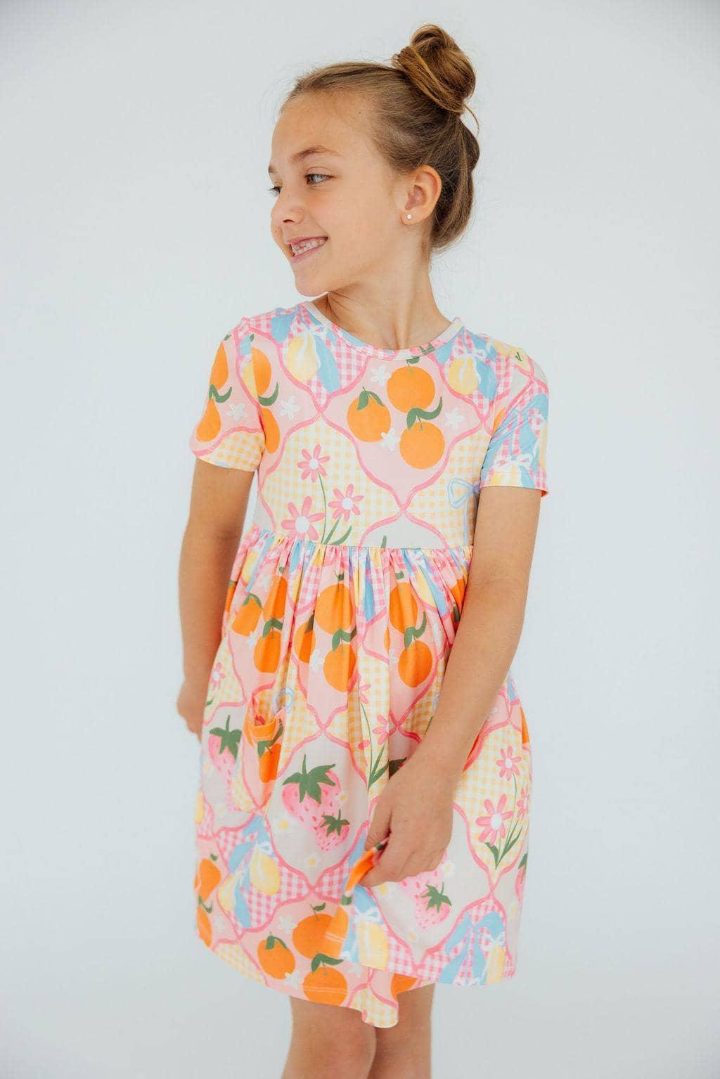 Girls colorful twirl dress with pockets in pastel orange and pink floral print, short sleeve