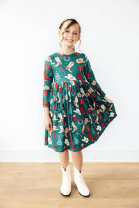Girls green western themed twirl dress with long sleeves and pockets, holiday print for kids