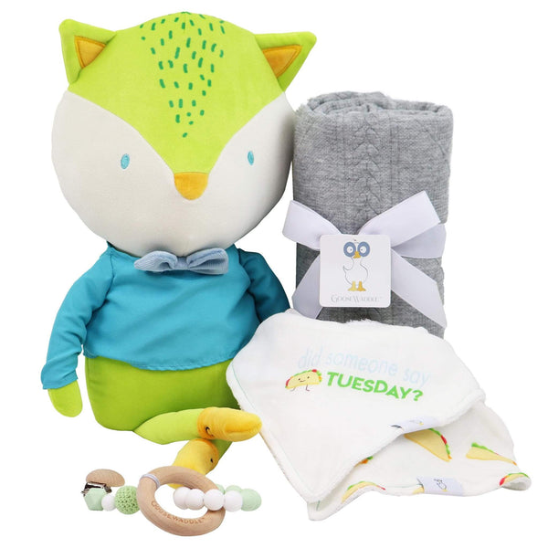 Goosewaddle gift set with green and blue fox plush toy, gray baby blanket, white bib with Tuesday print, and silicone teether rings for newborns
