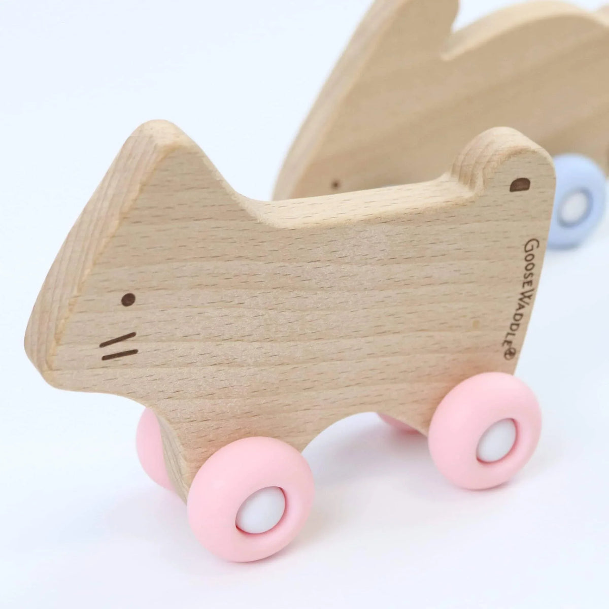 Natural wood and pink silicone wood baby teether shaped like a cat with wheels by Goosewaddle