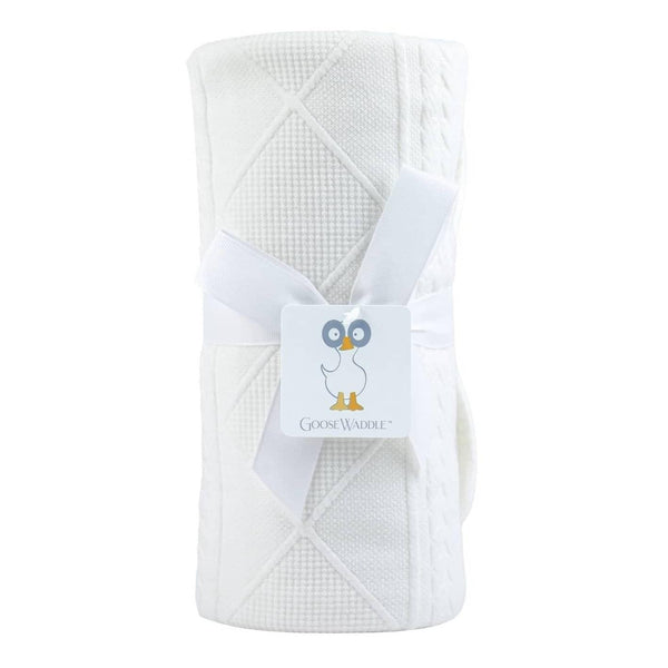 White baby knit blanket made of soft cotton with textured diamond and cable knit patterns