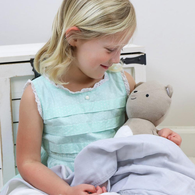 A joyful child sitting with the Bear Knit Plush, highlighting the loving companionship this soft toy offers during nap time and playtime.