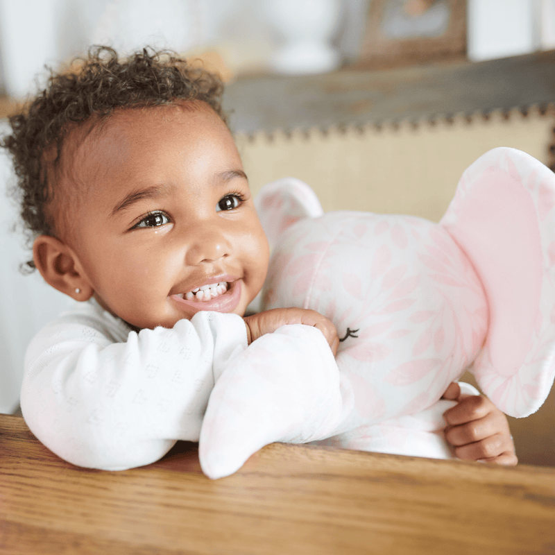 Happy child hugging a Super Soft Printed Plush 15-inch pink elephant toy, showcasing warmth and companionship.