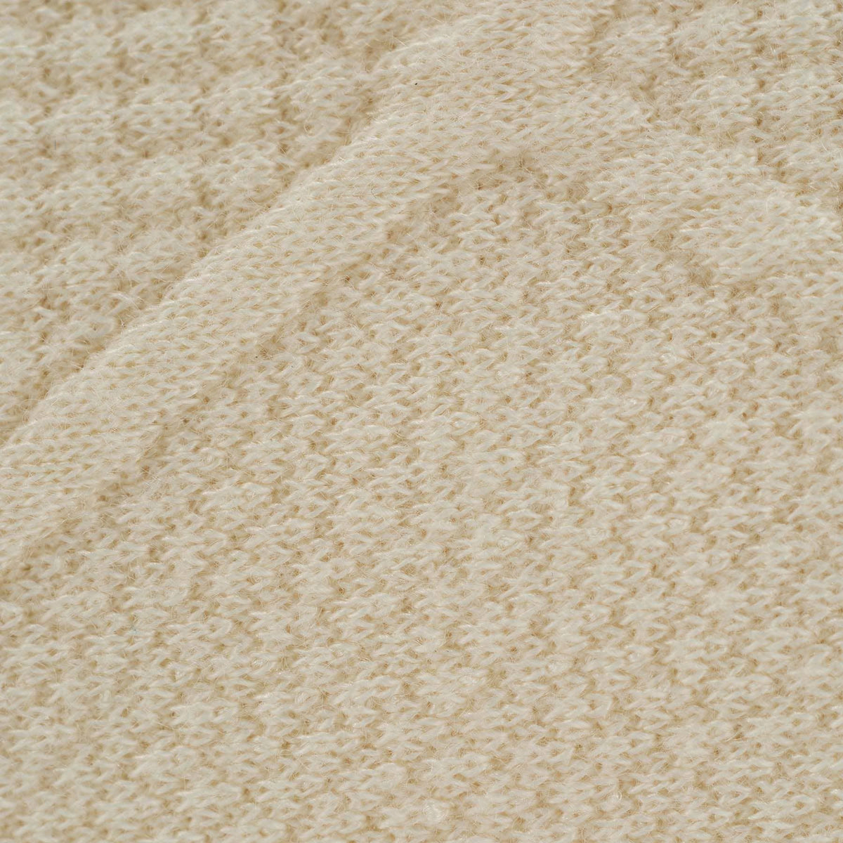 Close-up of oatmeal knit baby blanket showing soft textured knit pattern and warm neutral color